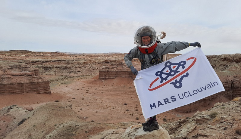 Julie Manon (crew health and safety officer) avec le drapeau M.A.R.S UCLouvain devant le canyon © M.A.R.S UCLouvain